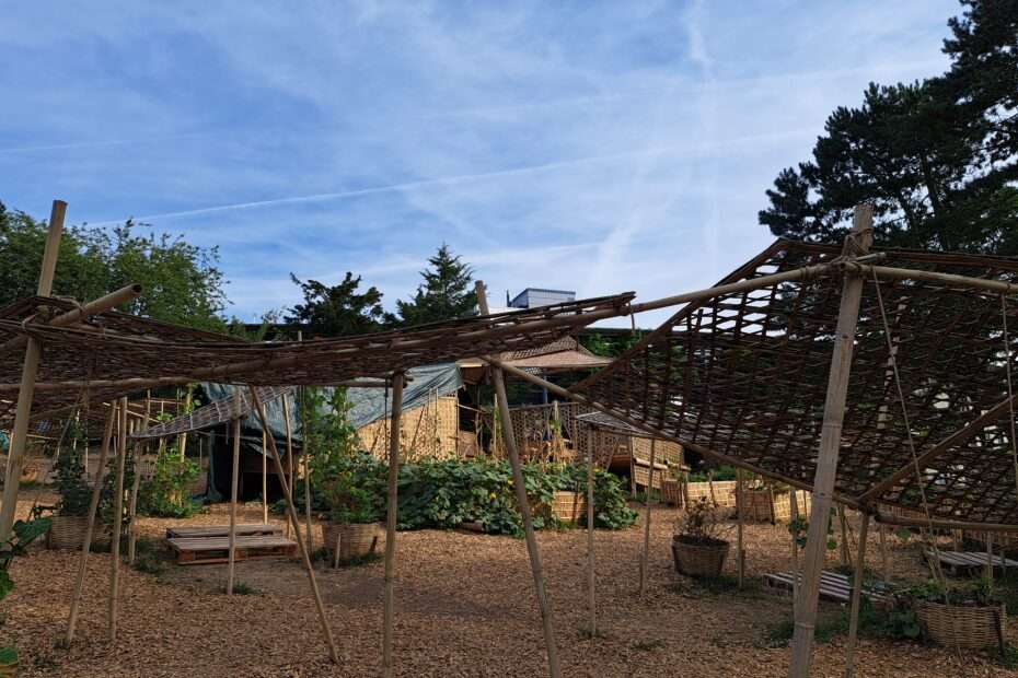 Eine Hütte auf Naturmaterialien wie holz, Bambus und Ähnlichem im Aussenbereich der Dokumenta das auch als Klettergerüst und Beet für Gemüse dient
