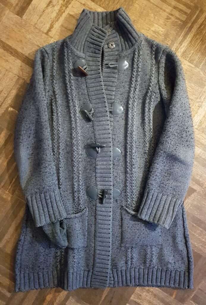 Here the button is already attached to the upcycled and repaired cardigan