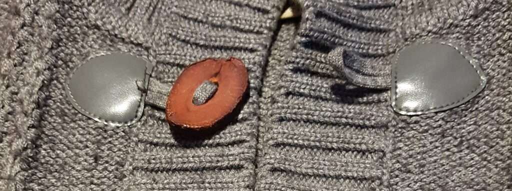 Here the button is already attached to the upcycled and repaired cardigan