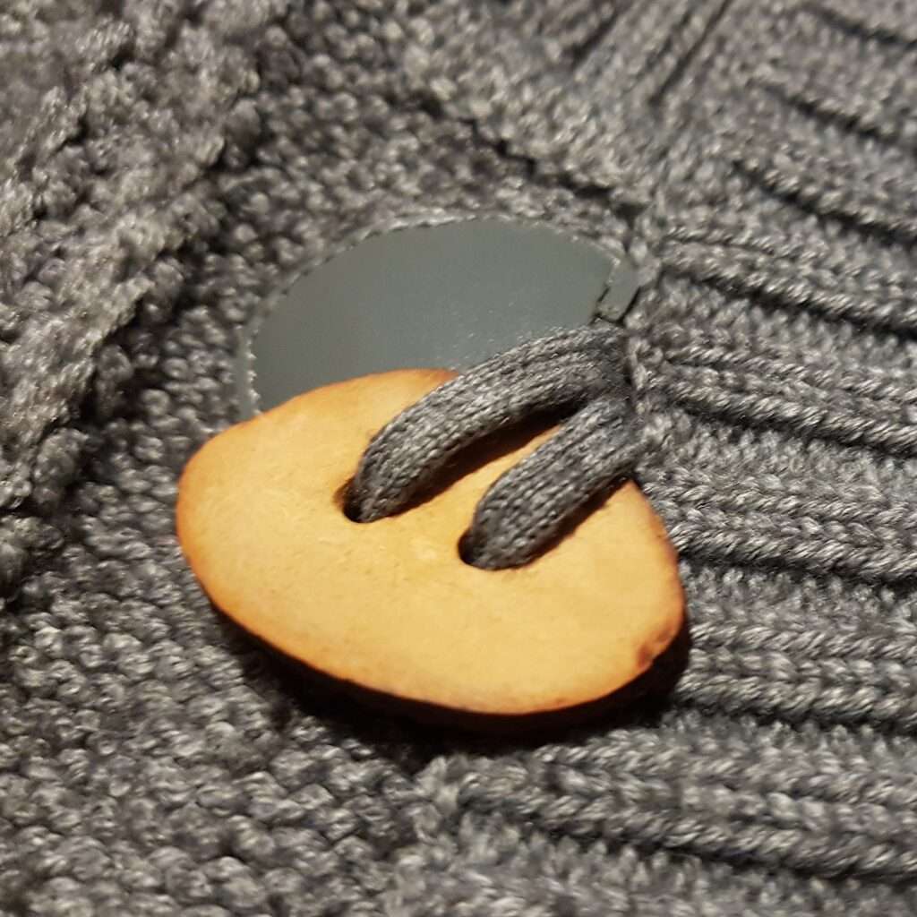 Avocado seed button on a upcycled cardigan