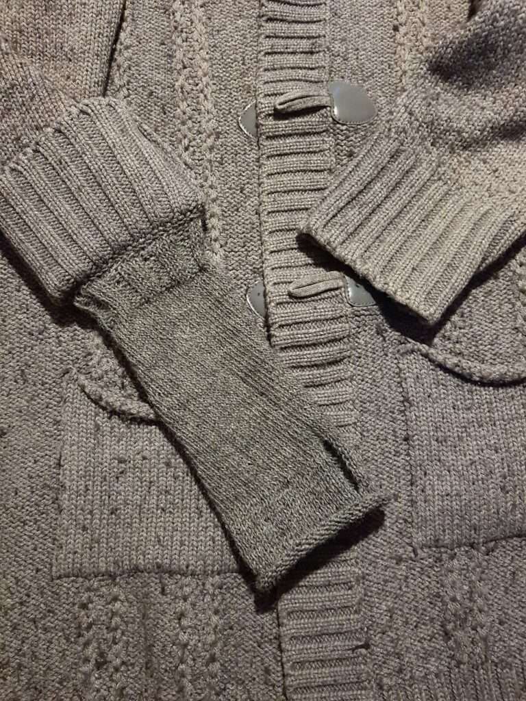 knitted attached handwarmers on a cardigan