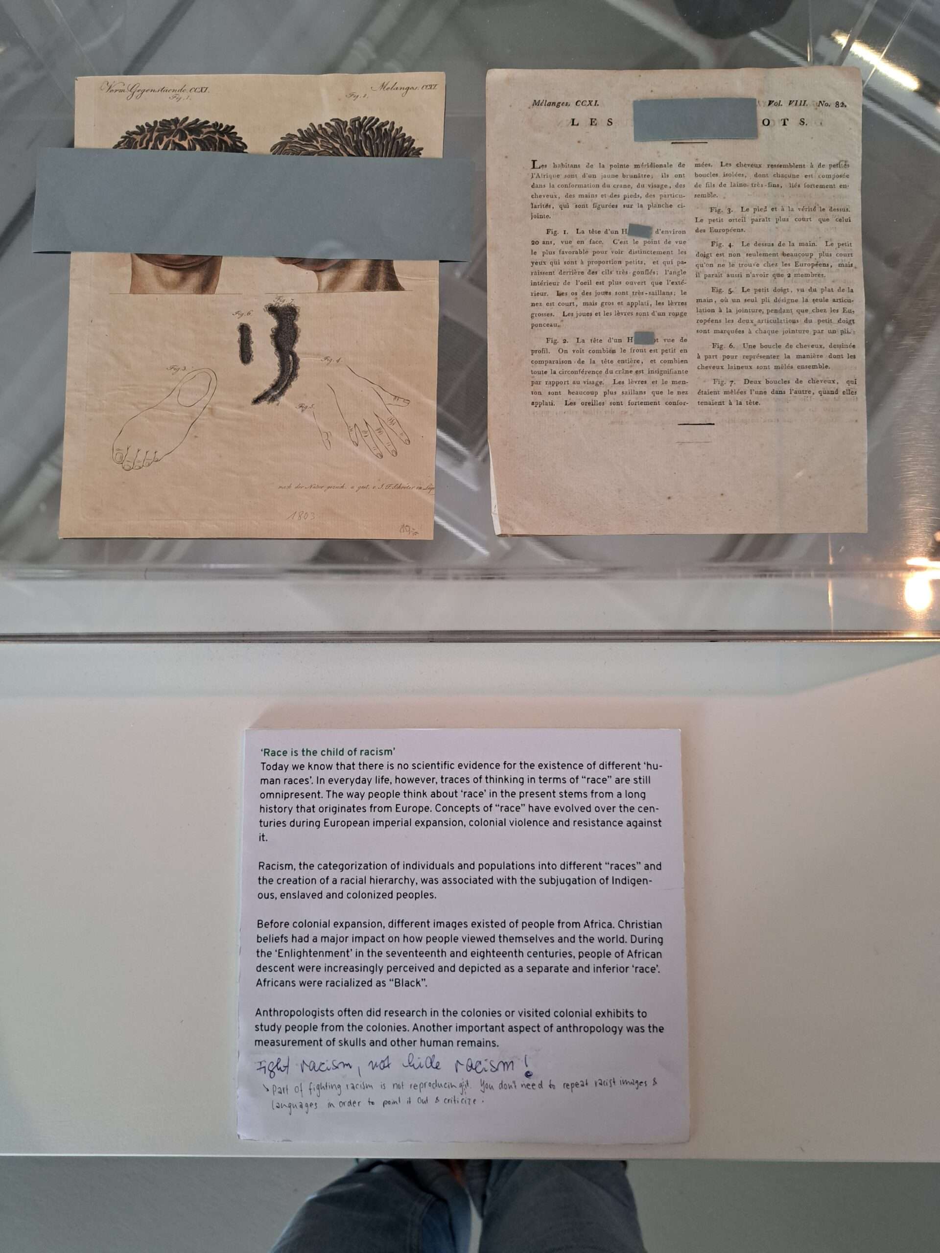 Two pages from older books which use and depict racists imagery and words are shown but the words and images are covered. Underneath the explanation someone wrote "Fight racism, not hide racism" to which there is another written remark reading "Part of fighting racism is not reproducing it. You don't need to repeat racist images and language in order to point it out and criticize."