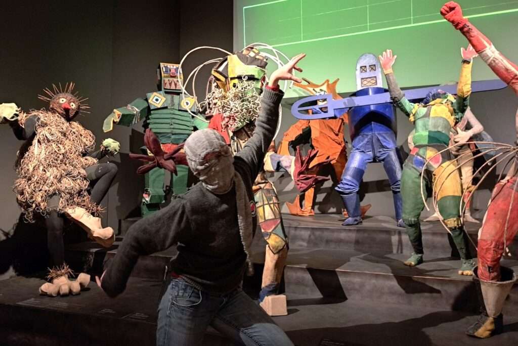 At the museum "Hamburger Kunsthalle", dancing with puppets.
Life sized costumes as a group with me in the foreground striking a pose with my grey scarf wrapped around my head.