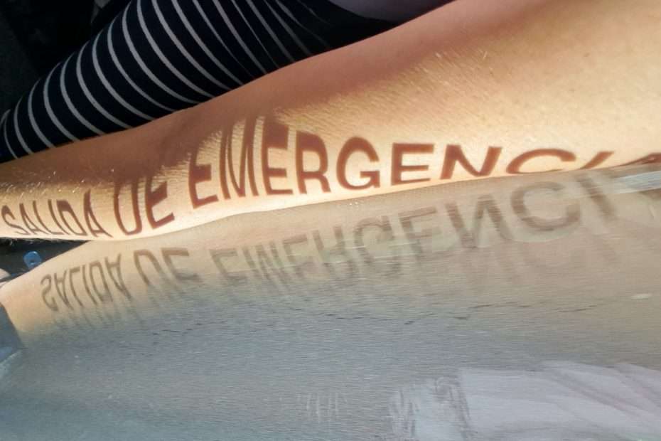 "Salida de Emergencia" worte die als Schatten auf einem Arm zu sehen sind